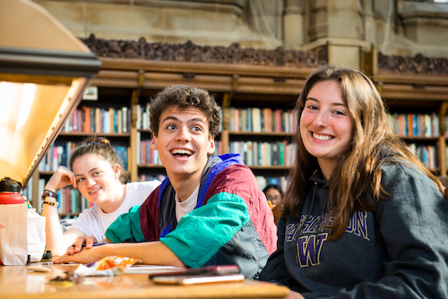Students smiling in Suzallo library.