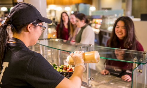 Student Employee Serving Food at Husky Den