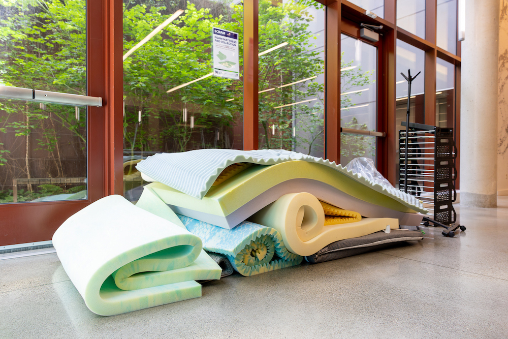 A pile of foam mattress toppers