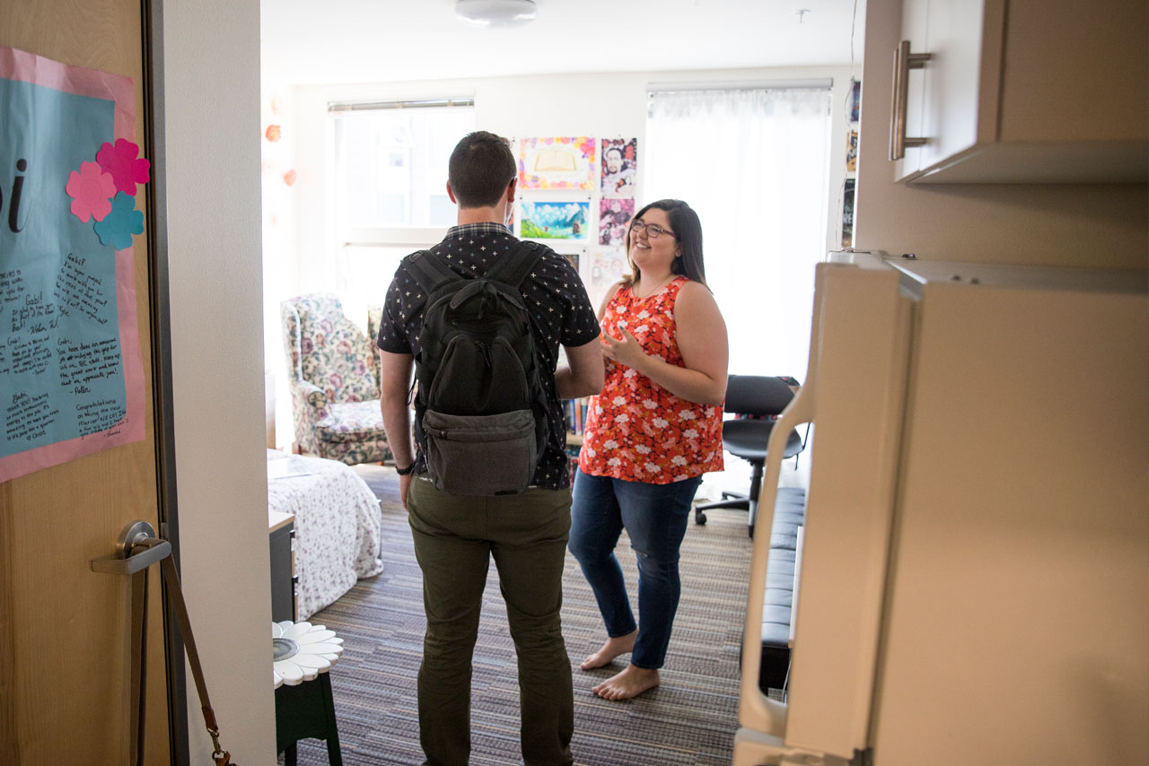 Grad students in the doorway of a studio apartment in Mercer Court